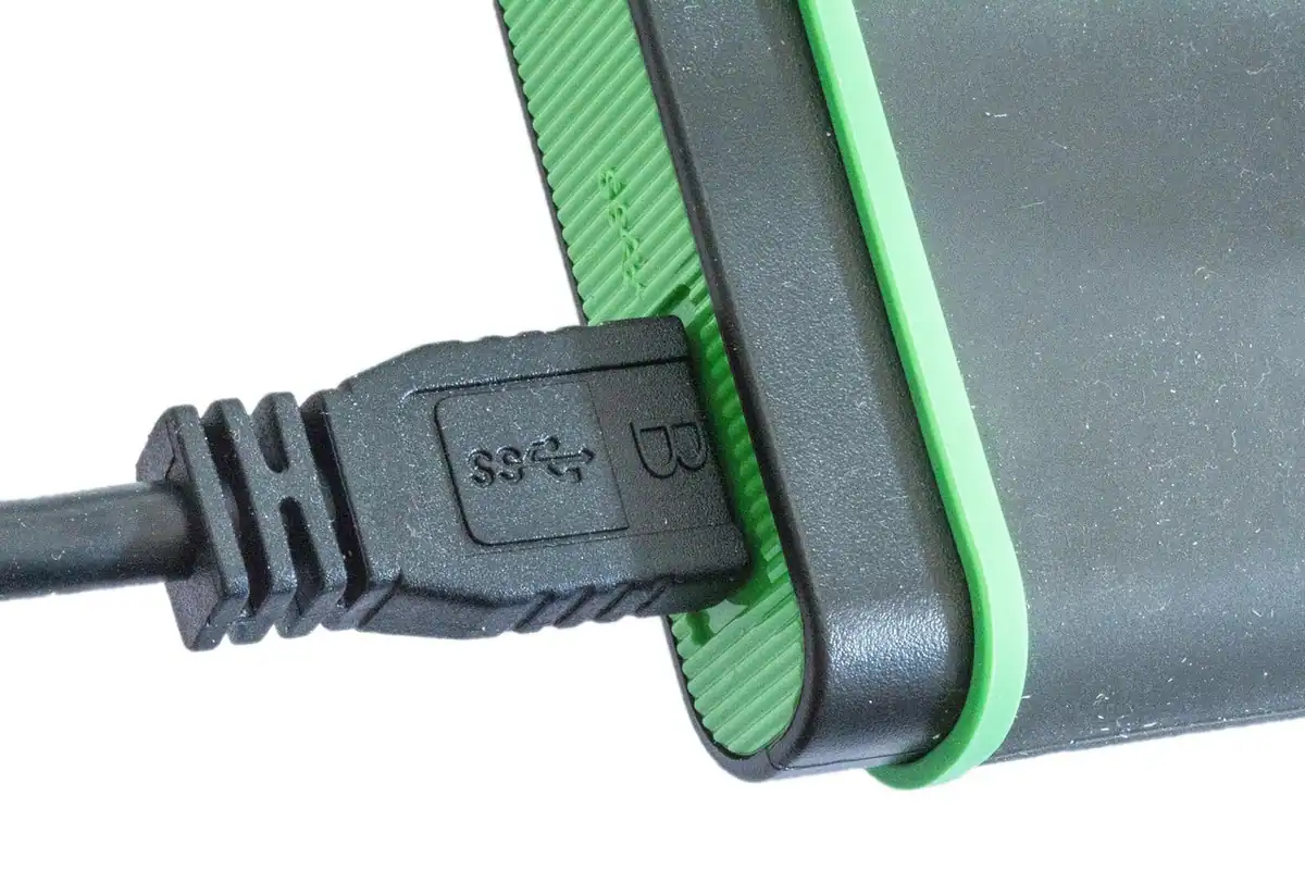 Cablu USB conectat la un hard disk extern cu margine verde