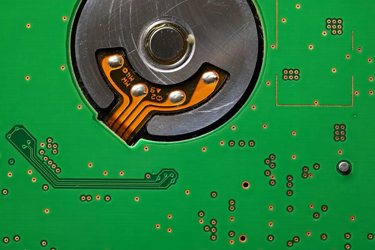 Interiorul unui hard disk montat pe placă electronică verde, loc unde stau datele tale