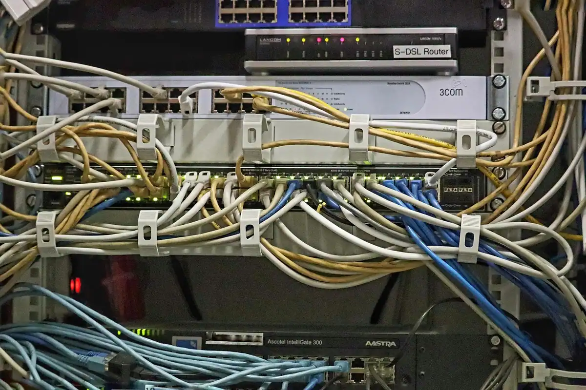 Panou de conexiuni dintr-un dulap de rețea, cu zeci de cabluri ethernet colorate