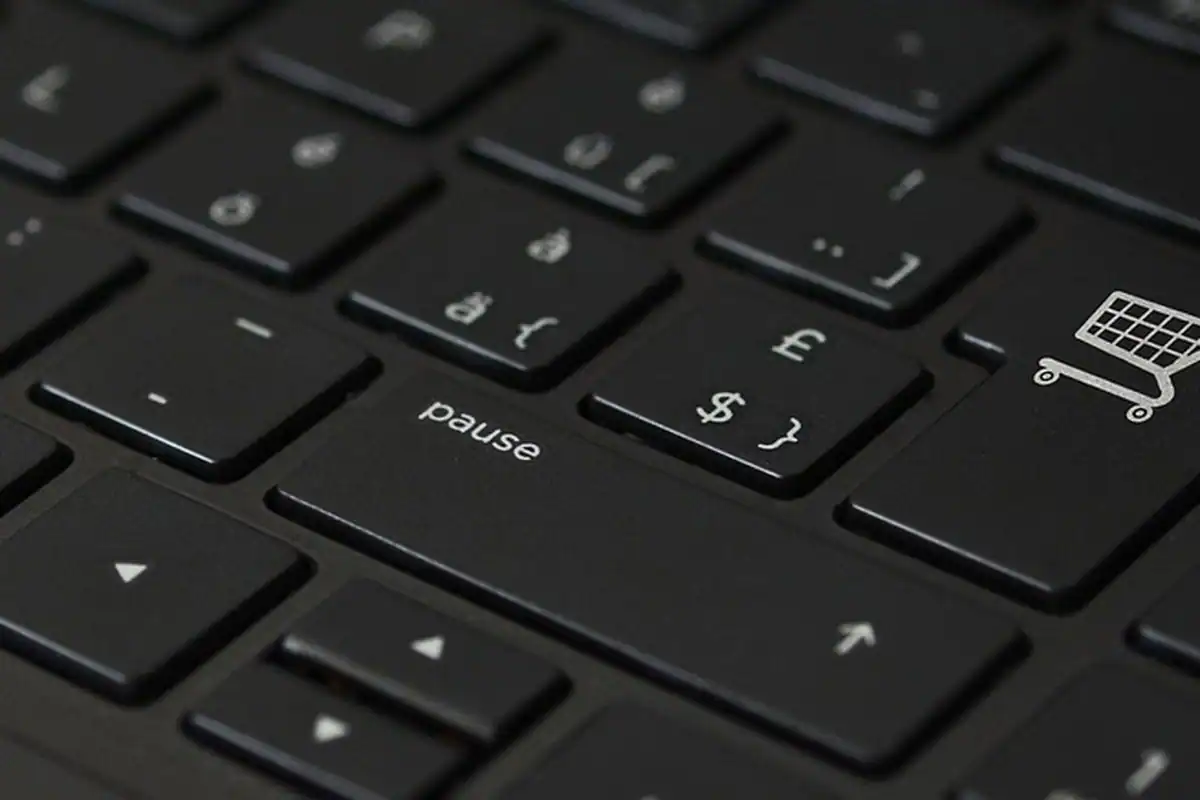 Taste negre de laptop, cu un mic simbol de coș de cumpărături lângă ele