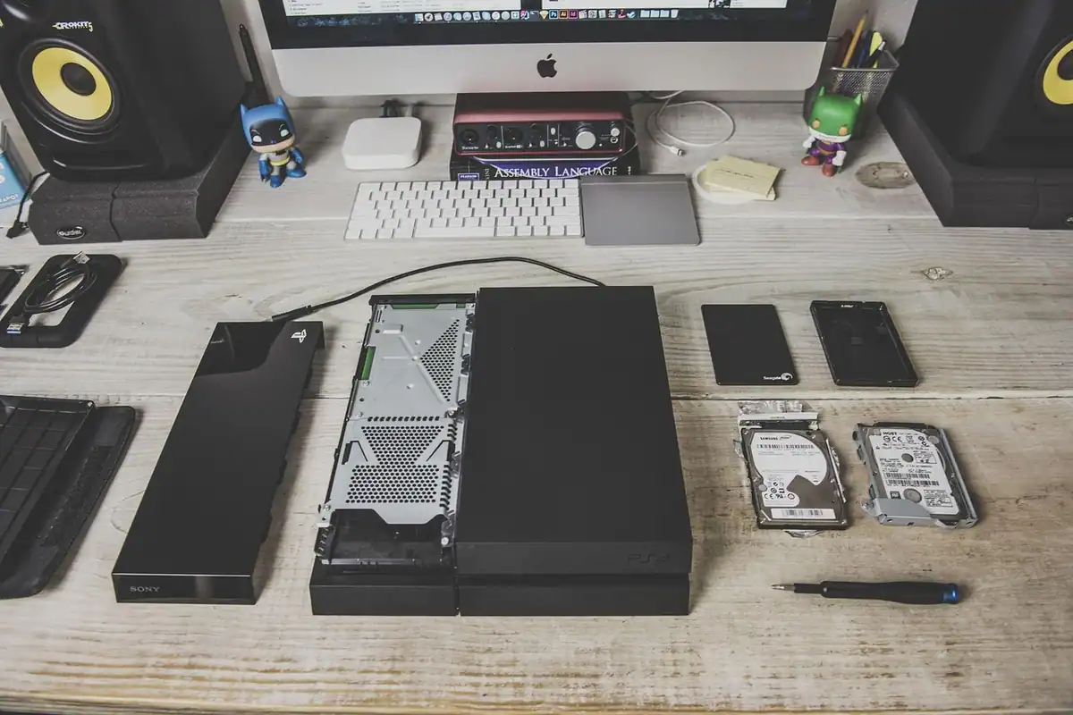 Hard disk extern așezat pe un birou, lângă tastatură și boxe